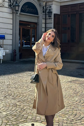 a lady in a long double-breasted coat with a belt